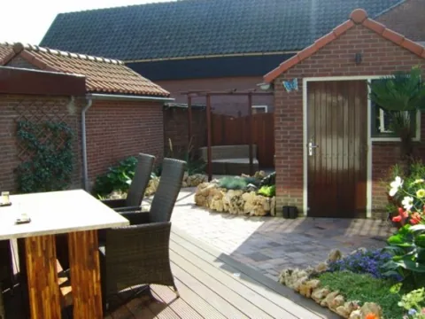 Onderhouden achtertuin met bloeiende borders, terras en tuinmeubelen